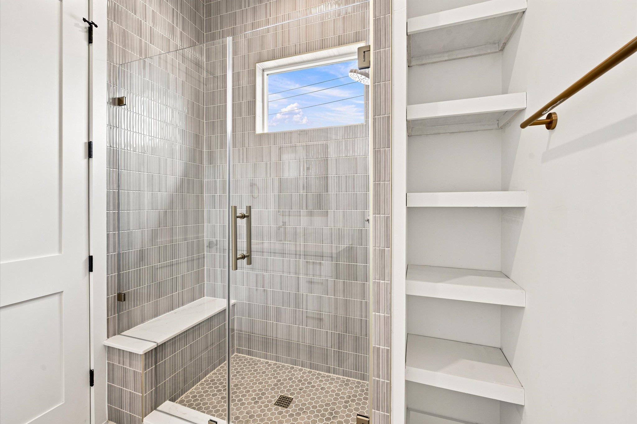 112 East 27th Street Houston, TX 77008 - Photo 30 of 43 Large walk-in shower with floor-to-ceiling tile, a frameless glass enclosure and convenient open shelving.