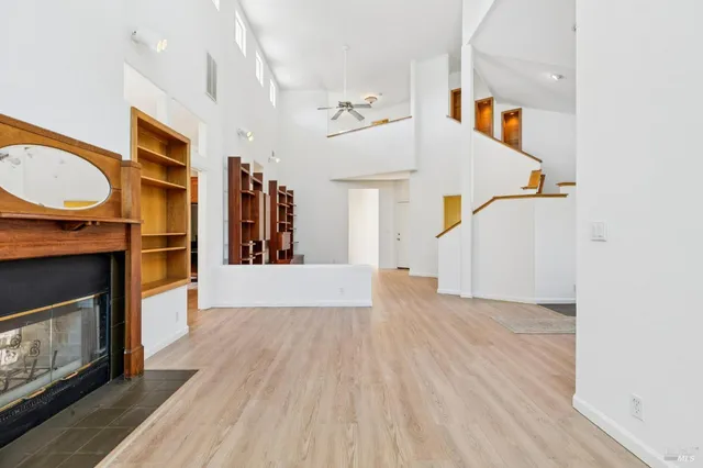 a view of an empty room with wooden floor and window