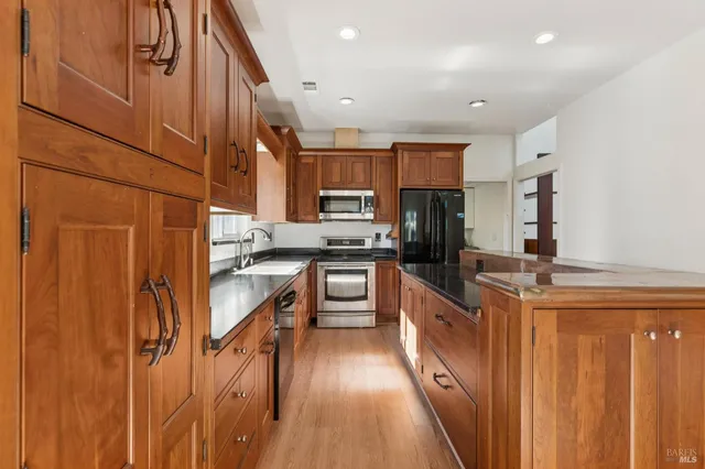 a kitchen with stainless steel appliances granite countertop a sink stove and refrigerator