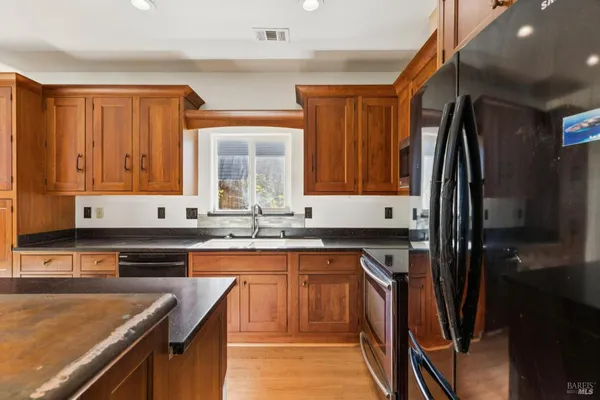 a kitchen with stainless steel appliances granite countertop wooden cabinets a sink and a stove
