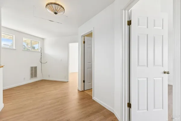 an empty room with wooden floor and closet