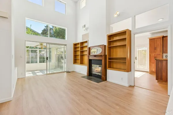 a view of a livingroom with wooden floor and a fireplace