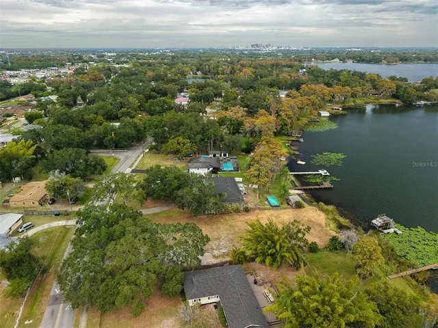 an aerial view of residential houses with outdoor space and trees