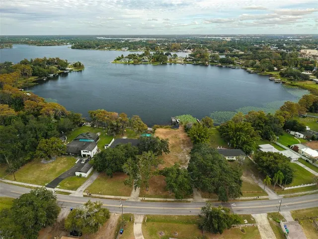 an aerial view of residential houses with outdoor space and lake view