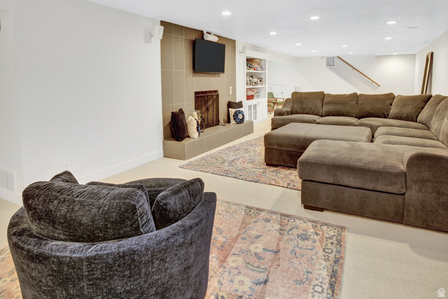 1350 Canyon Park Road Bountiful, UT 84010 - Photo 29 of 38 Recreational room featuring a fireplace with a tile surround and hearth, recessed lighting, built-in shelving, and carpet flooring