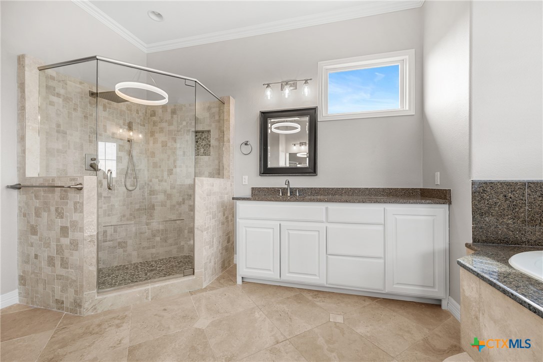 6717 Springwood Court Temple, TX 76502 - Photo 25 of 33 a spacious bathroom with a granite countertop sink mirror and shower