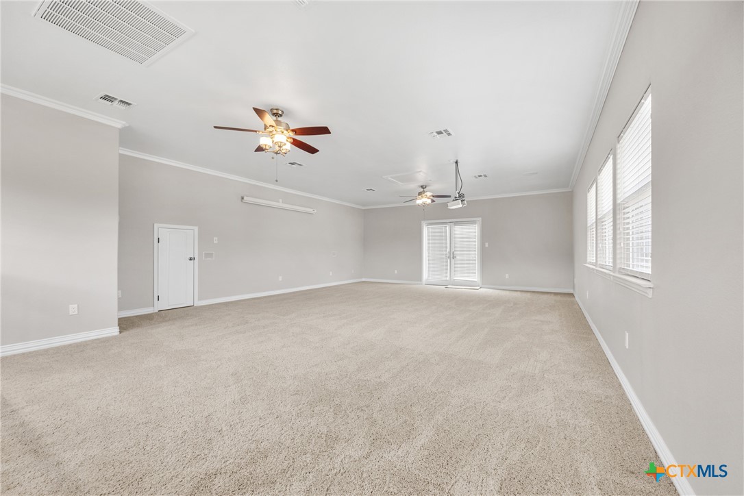 6717 Springwood Court Temple, TX 76502 - Photo 31 of 33 an empty room with chandelier fan and windows