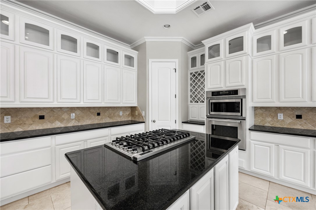 6717 Springwood Court Temple, TX 76502 - Photo 10 of 33 a kitchen with stainless steel appliances a stove a microwave and cabinets