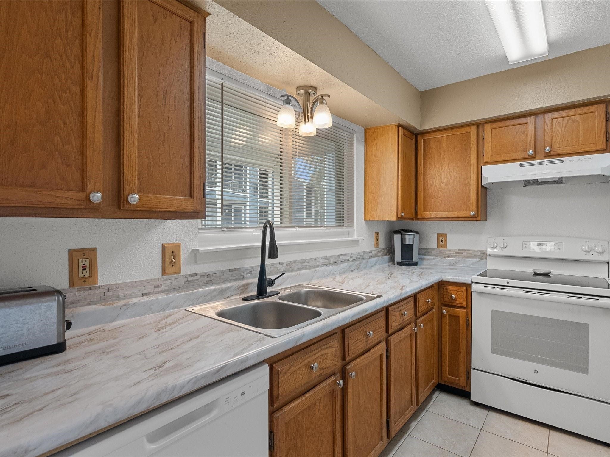18515 Egret Bay Boulevard, Unit 1101 Webster, TX 77058 - Photo 6 of 30 a kitchen with sink cabinets and window