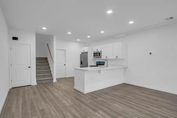 a view of kitchen with wooden floor and electronic appliances