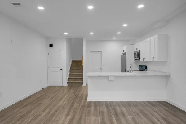 a view of kitchen with wooden floor and electronic appliances