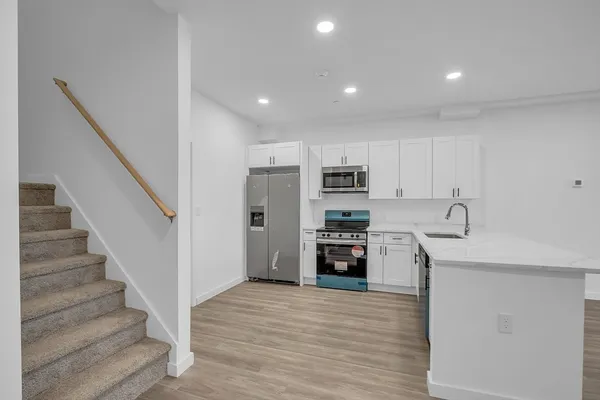 a view of kitchen with stainless steel appliances a refrigerator and a stove top oven