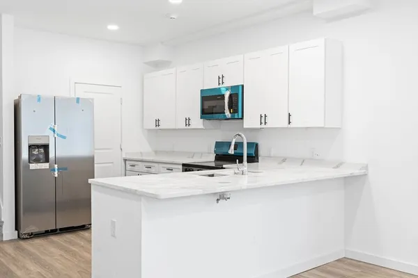 a kitchen with stainless steel appliances granite countertop a sink a stove a refrigerator a microwave and cabinets