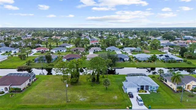 an aerial view of residential houses with outdoor space and trees