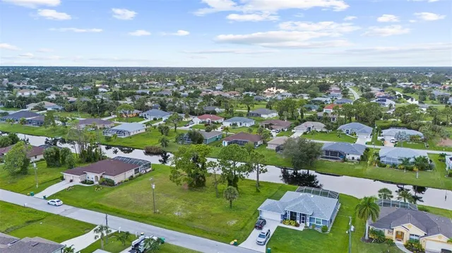 an aerial view of residential houses with outdoor space and trees