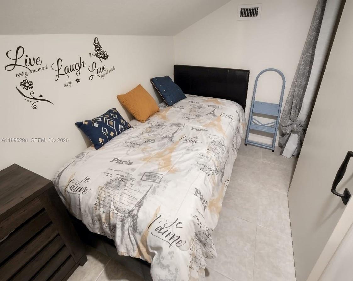 1016 Via Jardin, Unit 1016 Riviera Beach, FL 33418 - Photo 11 of 15 a bedroom with a bed and a white comforter