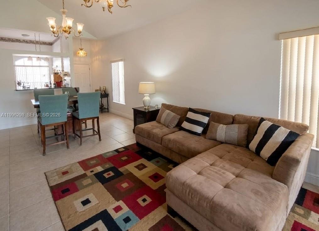 1016 Via Jardin, Unit 1016 Riviera Beach, FL 33418 - Photo 3 of 15 a living room with furniture a large window and a chandelier