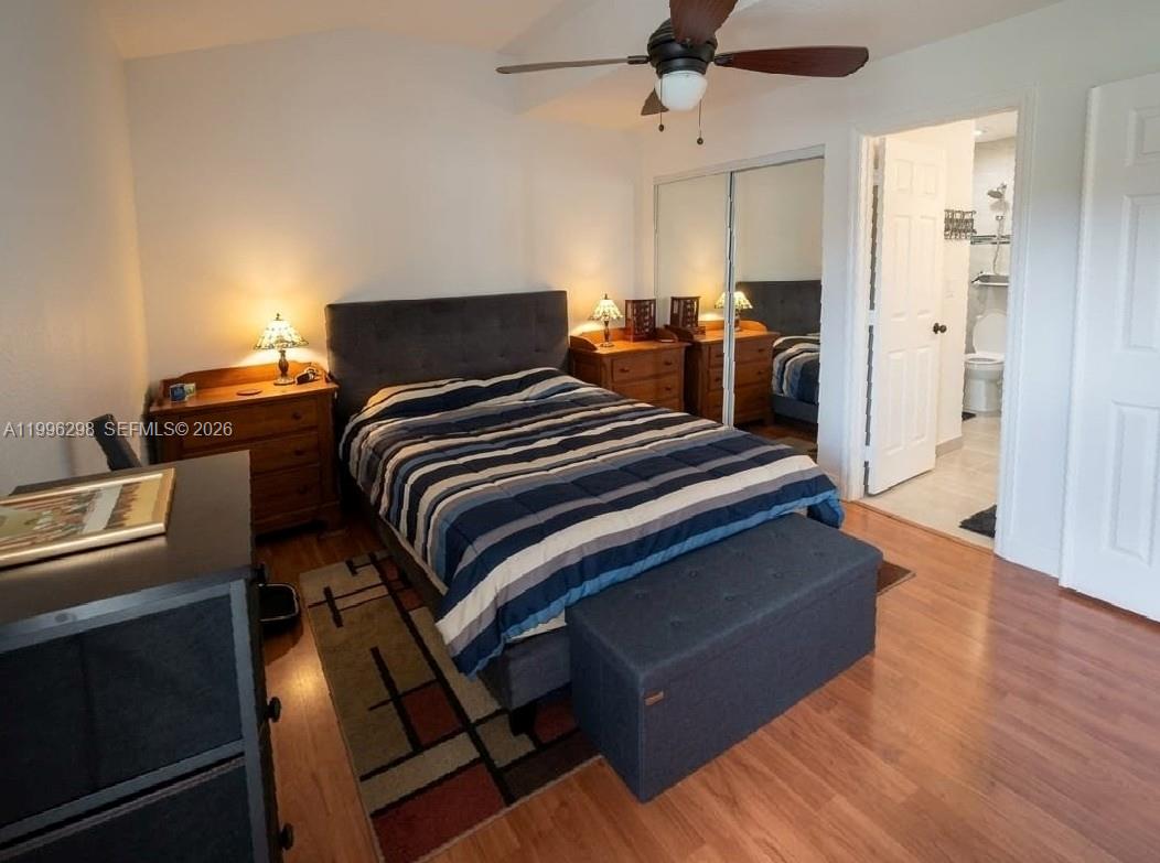 1016 Via Jardin, Unit 1016 Riviera Beach, FL 33418 - Photo 4 of 15 a bedroom with a bed and wooden floor