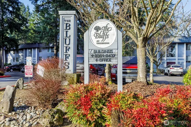 a sign board with buildings in the background