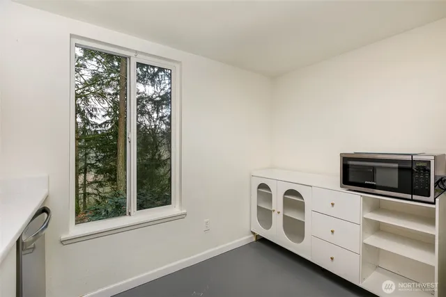 a view of an empty room with a fireplace and window