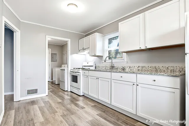 a kitchen with granite countertop white cabinets and white appliances