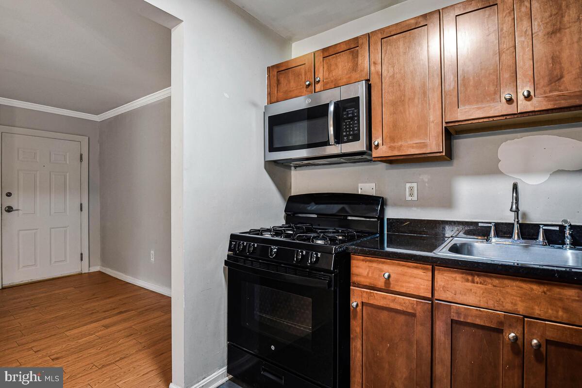 3103 Naylor Road Southeast, Unit 304 Washington, DC 20020 - Photo 12 of 28 a kitchen with stainless steel appliances granite countertop a stove microwave and sink