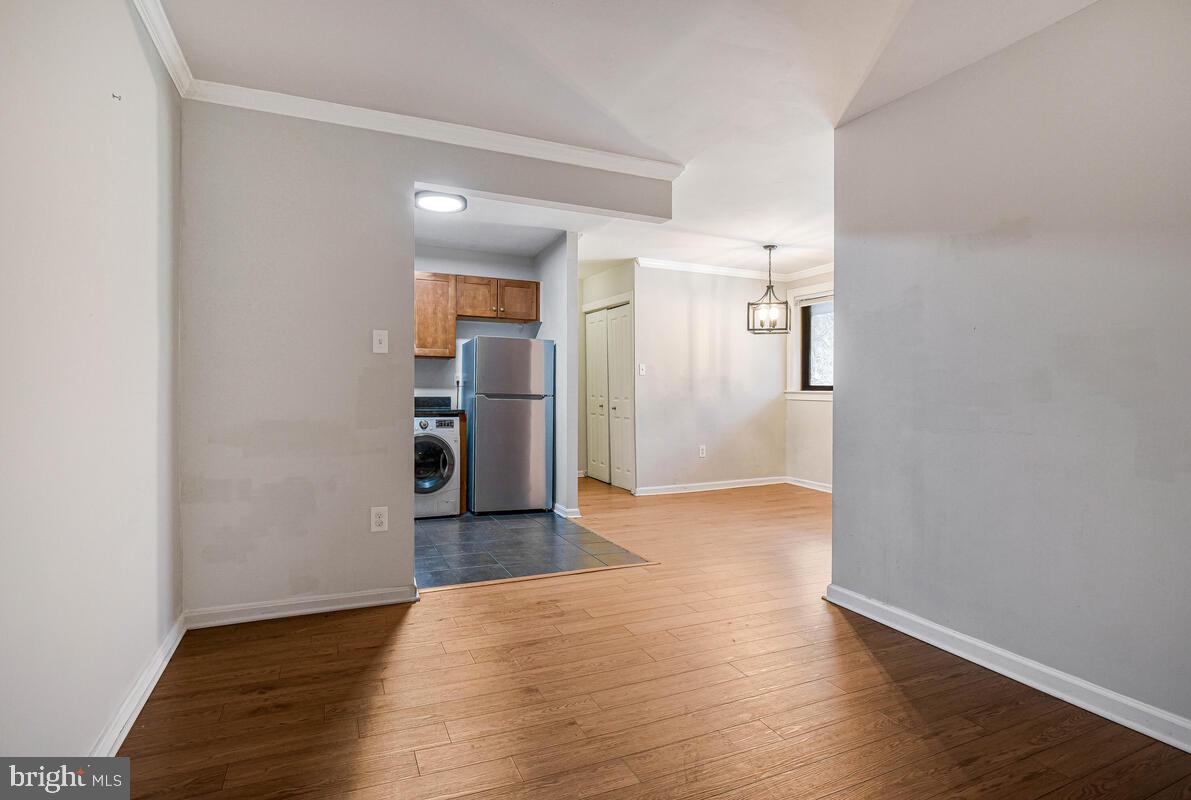 3103 Naylor Road Southeast, Unit 304 Washington, DC 20020 - Photo 8 of 28 a view of a kitchen with wooden floor and a refrigerator