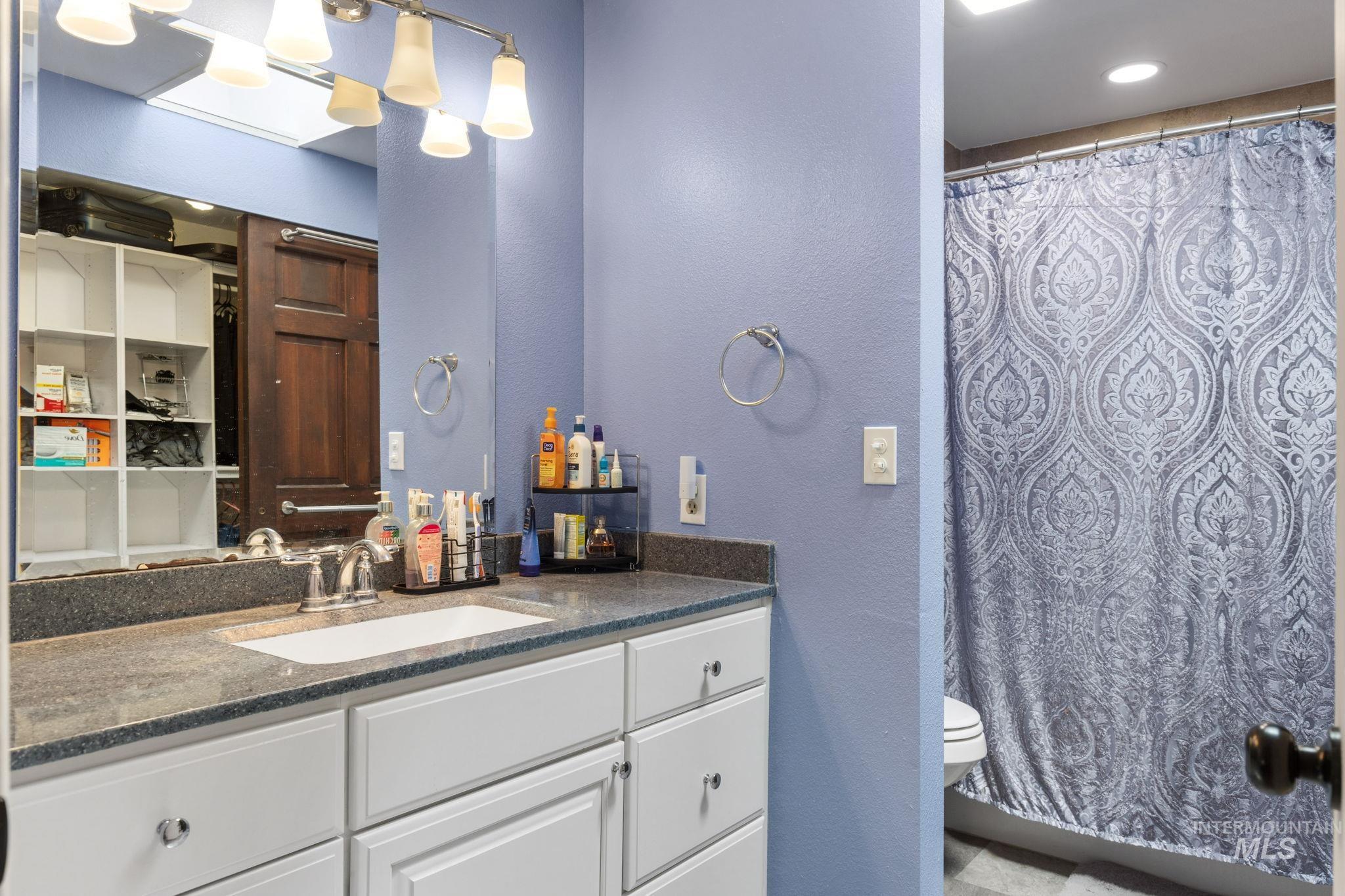 18338 Pride Lane Caldwell, ID 83607 - Photo 25 of 50 Bathroom featuring a vanity with a white basin, chrome faucet, and grey speckled countertop