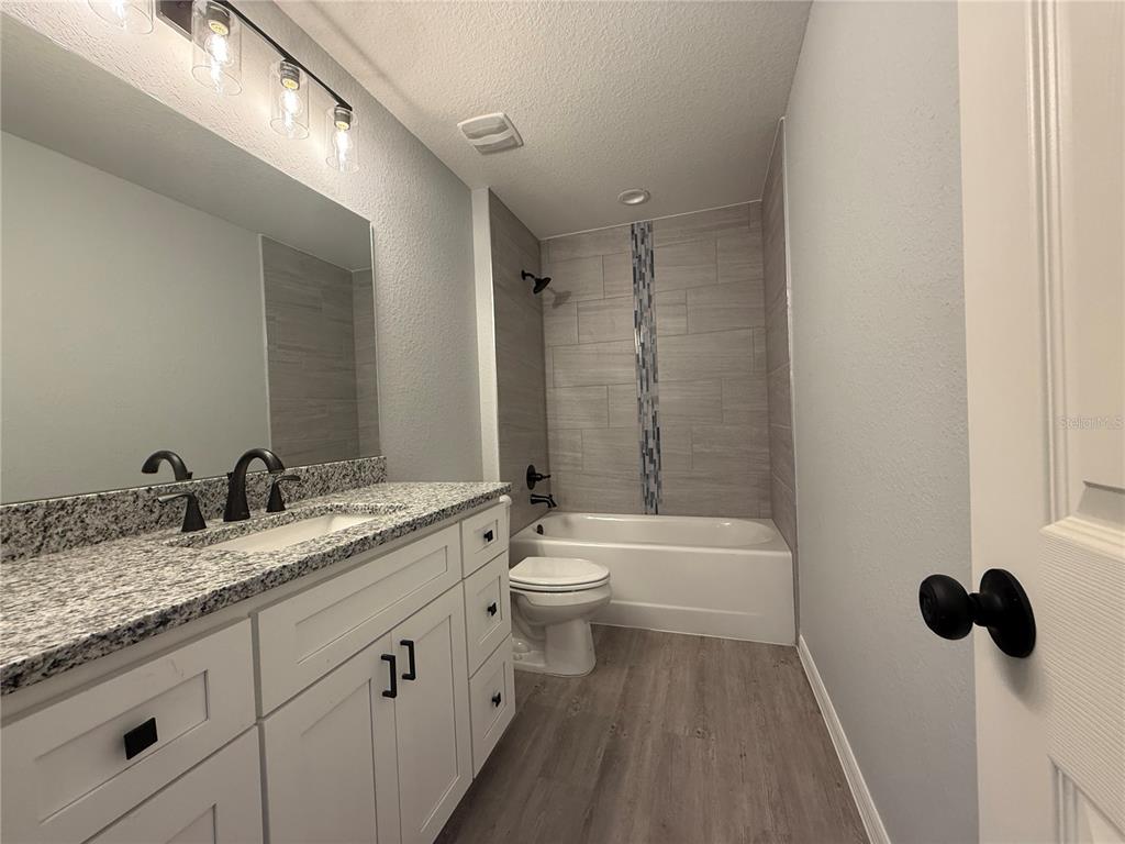19 Northwest 45th Loop Ocala, FL 34475 - Photo 11 of 28 a bathroom with a granite countertop sink a toilet and shower