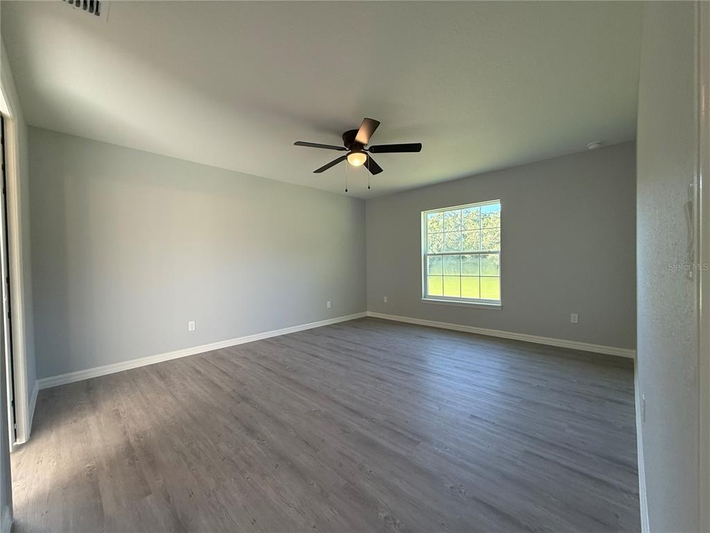 19 Northwest 45th Loop Ocala, FL 34475 - Photo 13 of 28 an empty room with wooden floor and windows