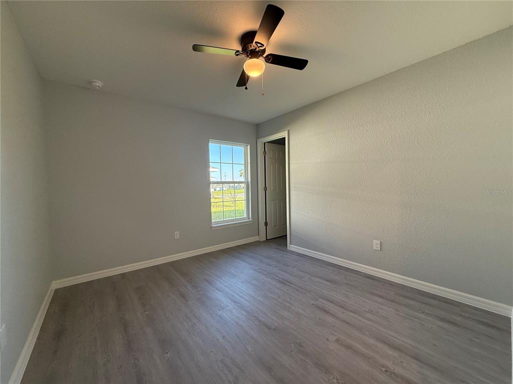 19 Northwest 45th Loop Ocala, FL 34475 - Photo 15 of 28 wooden floor in an empty room with a window