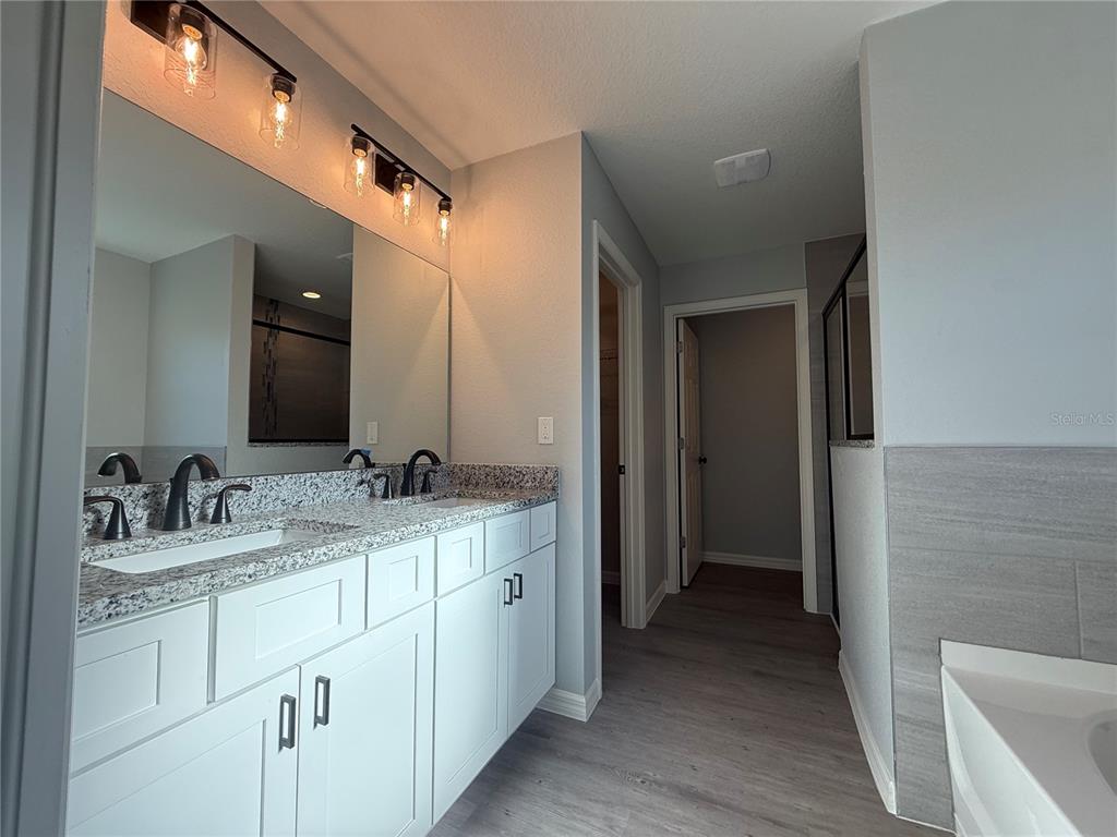 19 Northwest 45th Loop Ocala, FL 34475 - Photo 18 of 28 a en suite bathroom with a double vanity sink and a mirror