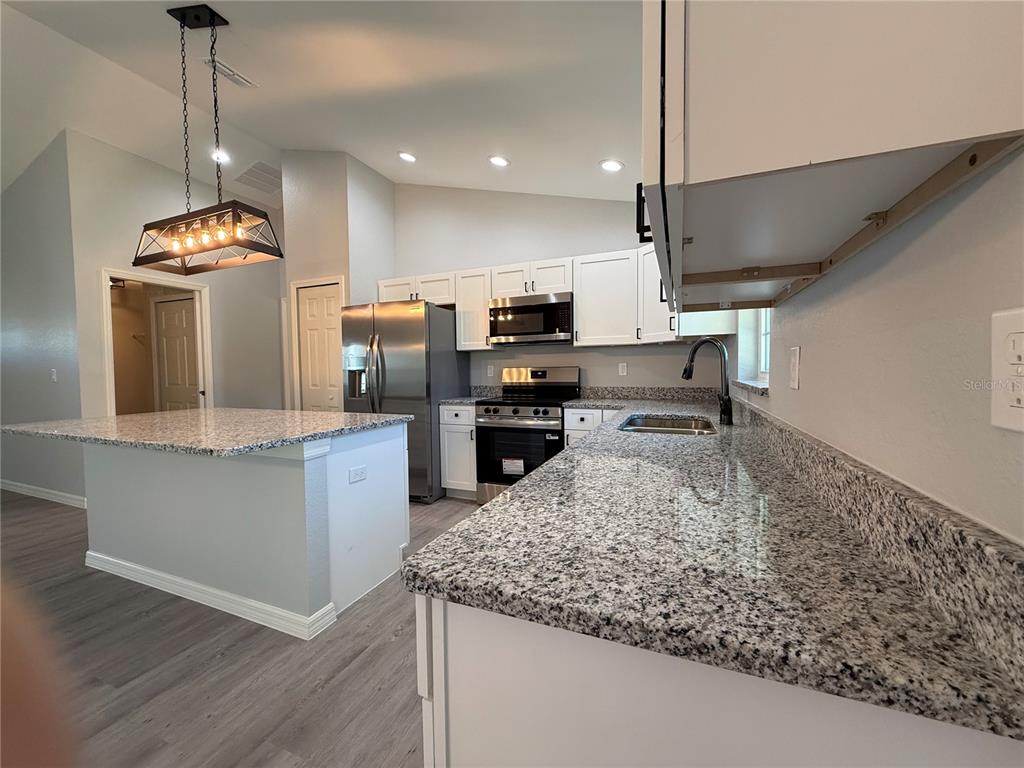 19 Northwest 45th Loop Ocala, FL 34475 - Photo 4 of 28 a kitchen with a sink a counter top space appliances and cabinets