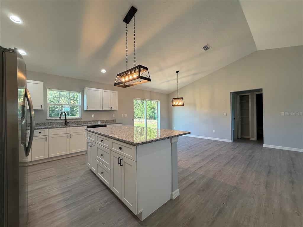 19 Northwest 45th Loop Ocala, FL 34475 - Photo 5 of 28 a kitchen with kitchen island white cabinets and wooden floor