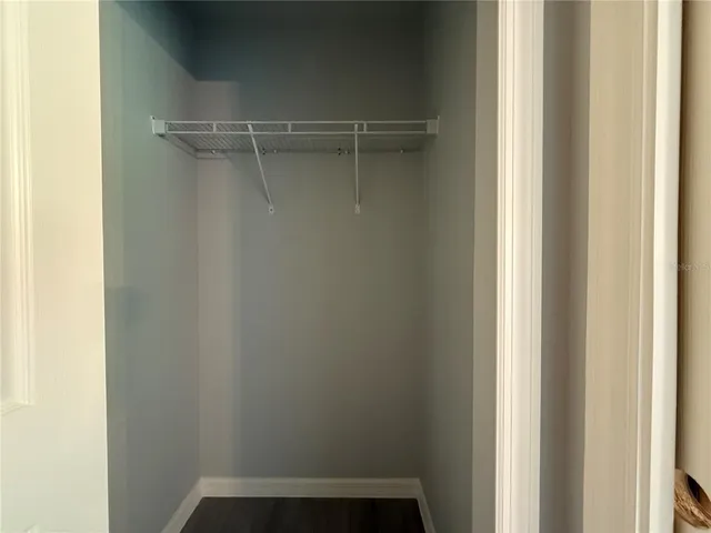 a view of a room with wooden floor ceiling fan and window