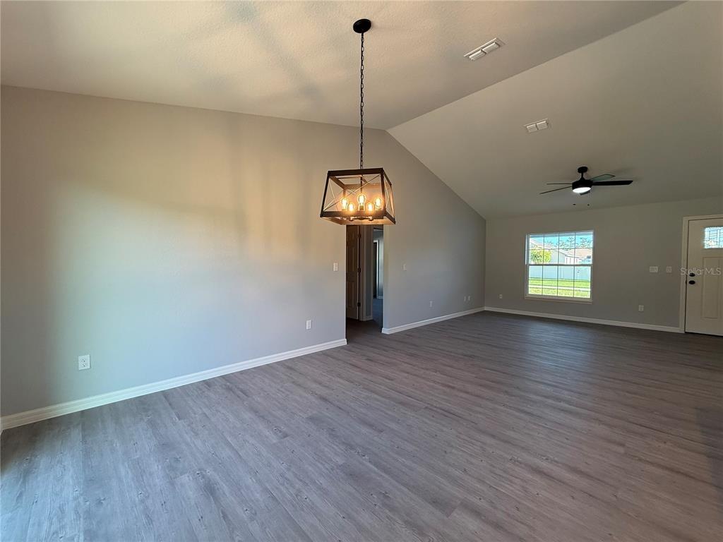 19 Northwest 45th Loop Ocala, FL 34475 - Photo 9 of 28 a view of a room with wooden floor ceiling fan and window