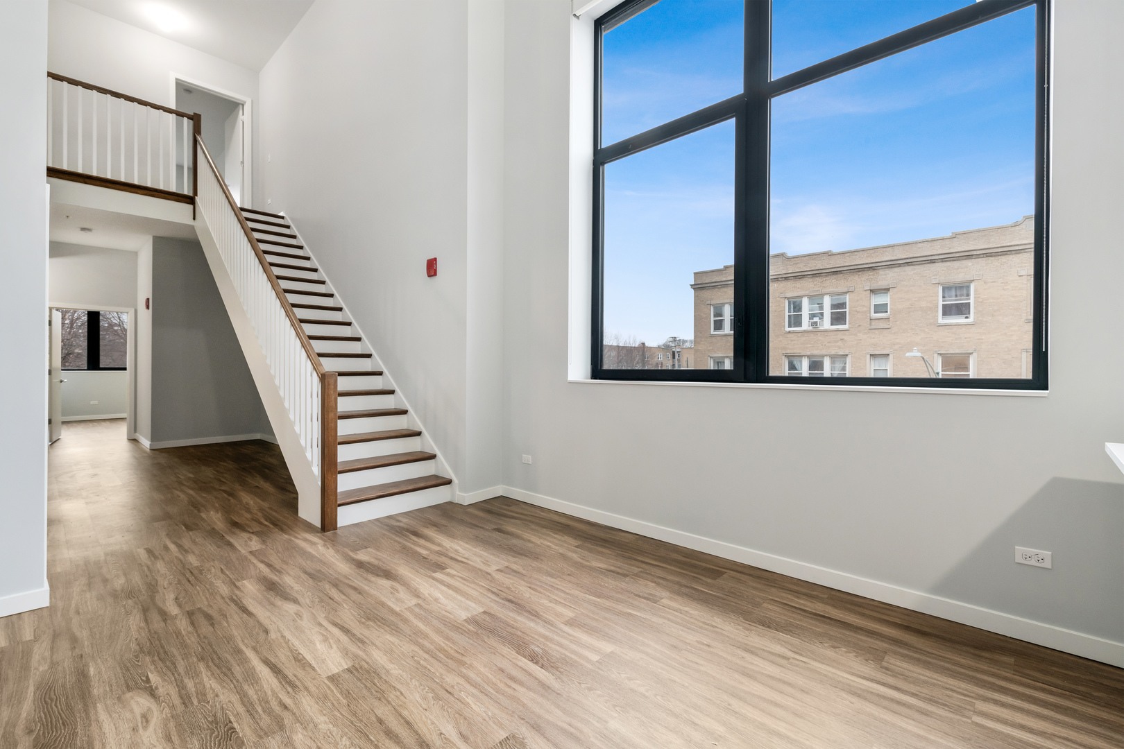 1900 West Lawrence Avenue, Unit 231 Chicago, IL 60640 - Photo 6 of 23 a view of a hallway with wooden floor and staircase