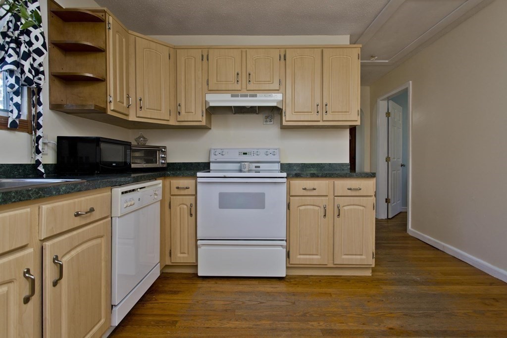 129 Eddy Street Springfield, MA 01104 - Photo 14 of 40 a kitchen with stainless steel appliances granite countertop a stove a sink and white cabinets