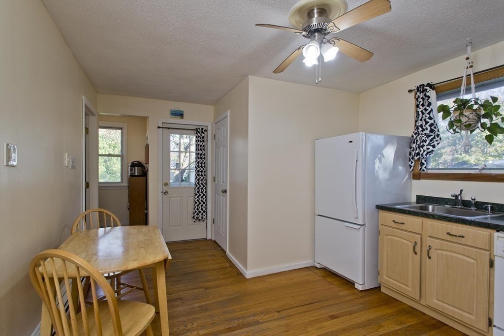 129 Eddy Street Springfield, MA 01104 - Photo 15 of 40 a kitchen with stainless steel appliances granite countertop a refrigerator a stove and a dining table with wooden floor