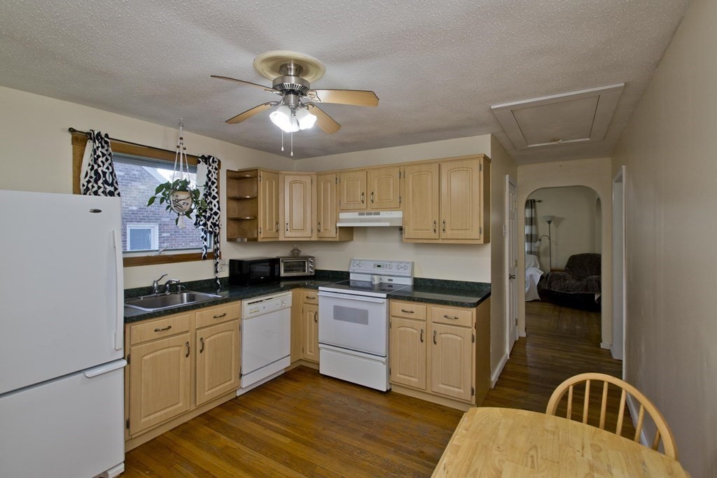 129 Eddy Street Springfield, MA 01104 - Photo 4 of 40 a kitchen with granite countertop a stove a sink dishwasher a refrigerator with wooden cabinets and floor
