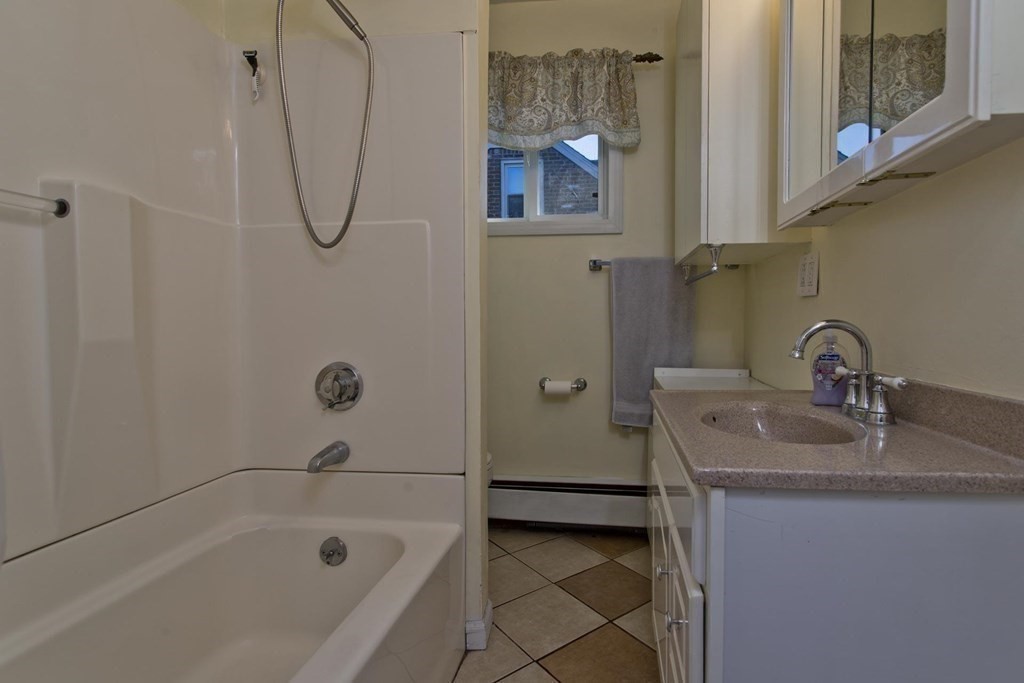 129 Eddy Street Springfield, MA 01104 - Photo 10 of 40 a bathroom with a sink a mirror and a bathtub