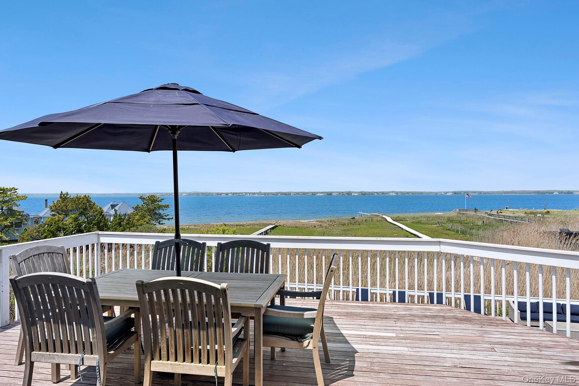 588 Dune Road Westhampton, NY 11978 - Photo 8 of 23 a view of a balcony with wooden floor and outdoor seating