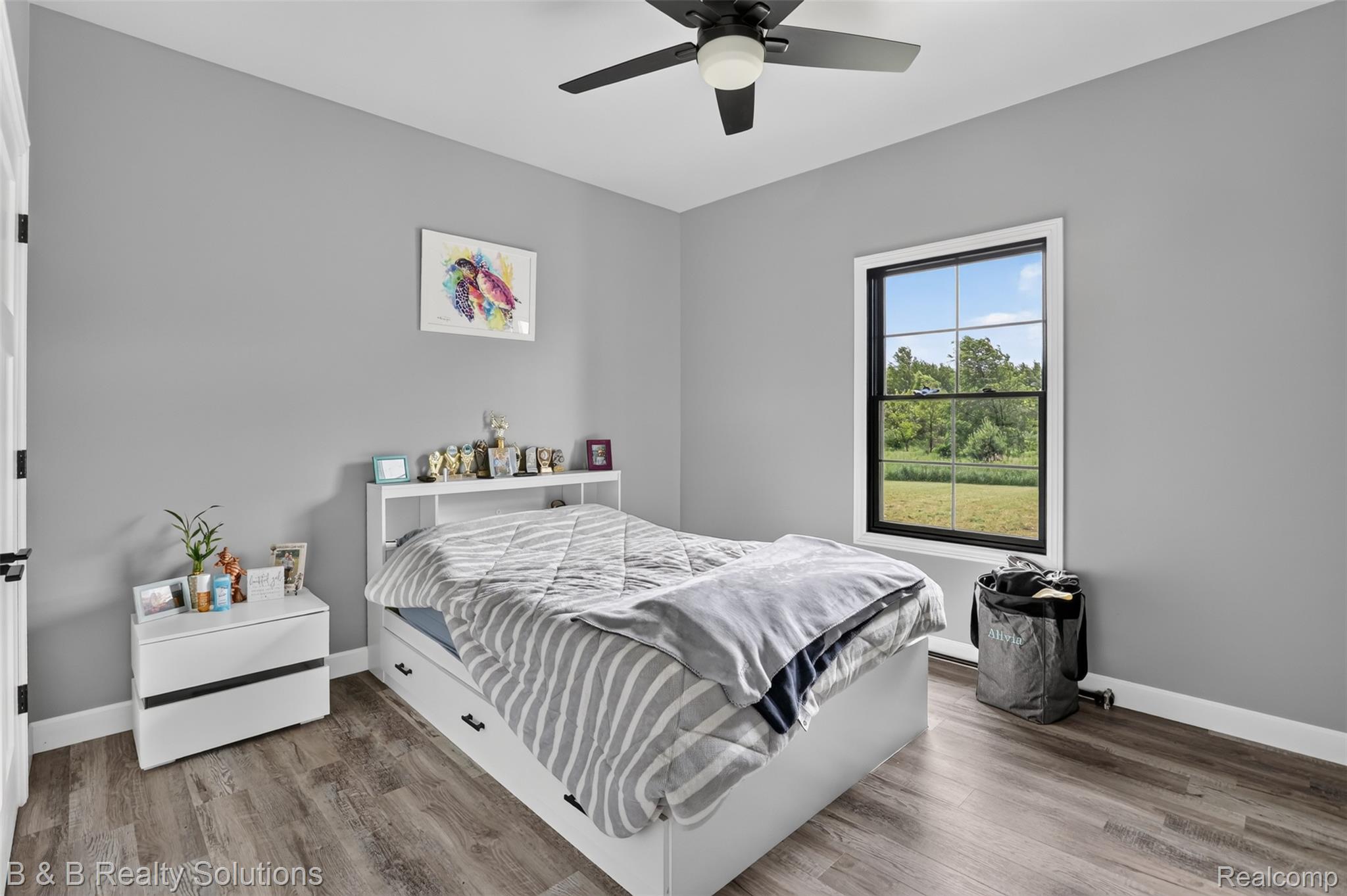 6204 Fish Lake Road North Branch, MI 48461 - Photo 38 of 79 Interior room featuring wood-finish flooring, light gray walls, and a black ceiling fan with an integrated light fixture