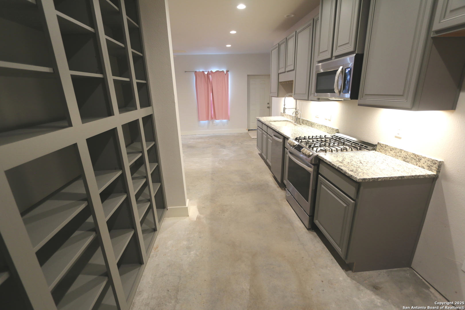1221 North Santa Clara Road Marion, TX 78124 - Photo 30 of 55 a kitchen with kitchen island granite countertop wooden cabinets and stainless steel appliances