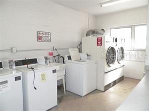 911 Washington Avenue Southwest, Unit 304 Largo, FL 33770 - Photo 24 of 26 a utility room with dryer washer and a view of kitchen