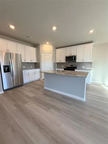 a kitchen with stainless steel appliances a refrigerator sink and microwave