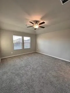 an empty room with windows and fan