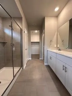 a bathroom with a double vanity sink mirror and shower