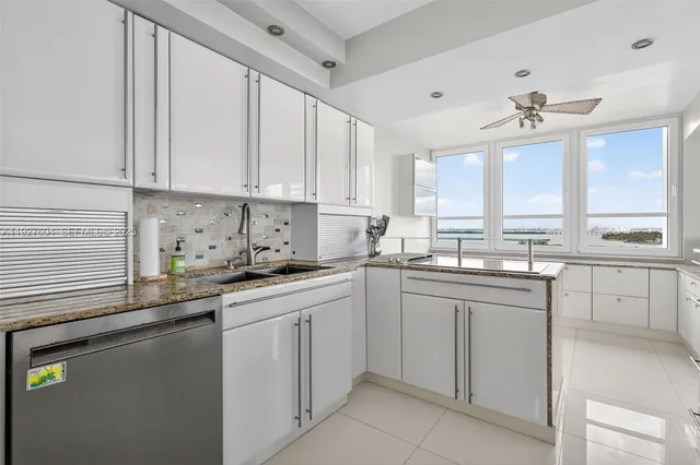 a kitchen with granite countertop white cabinets and stainless steel appliances