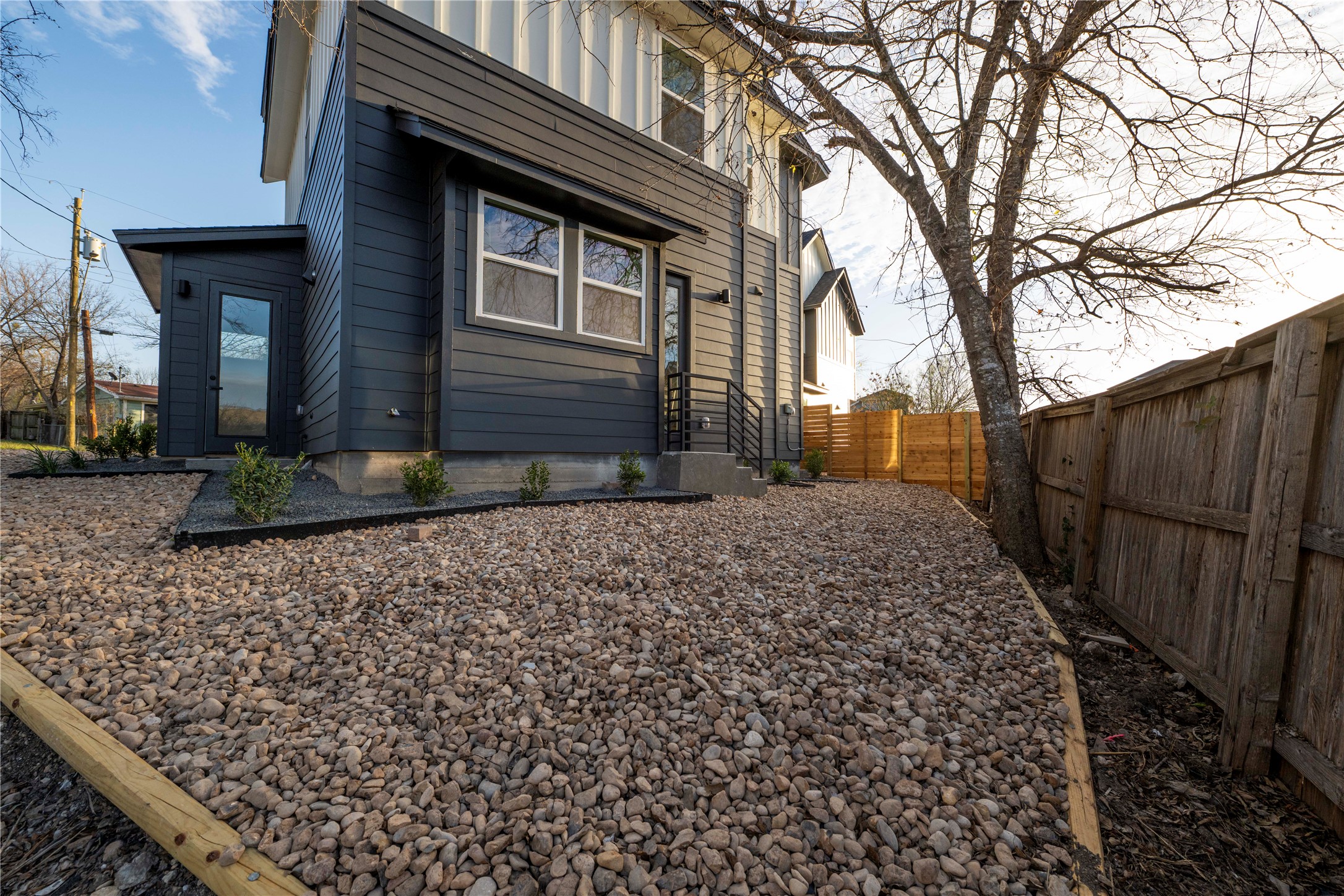 2220 Yellow Jacket Lane, Unit 1 Austin, TX 78741 - Photo 35 of 35 A modern facade with striking dark siding overlooks a low-maintenance gravel yard.